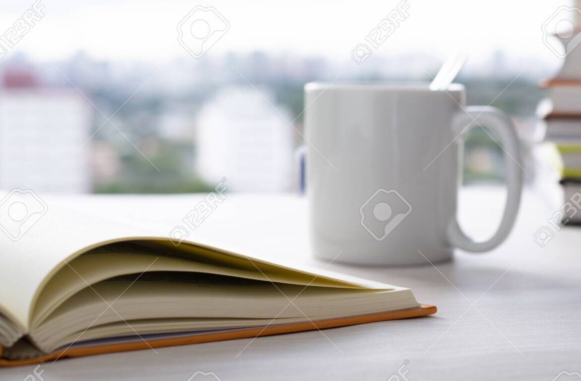 Catálogo del Rincón de Lectura: ¡Encuentra tus libros favoritos aquí! 1 una pila de libros abiertos en una mesa de madera con una taza de cafe al lado